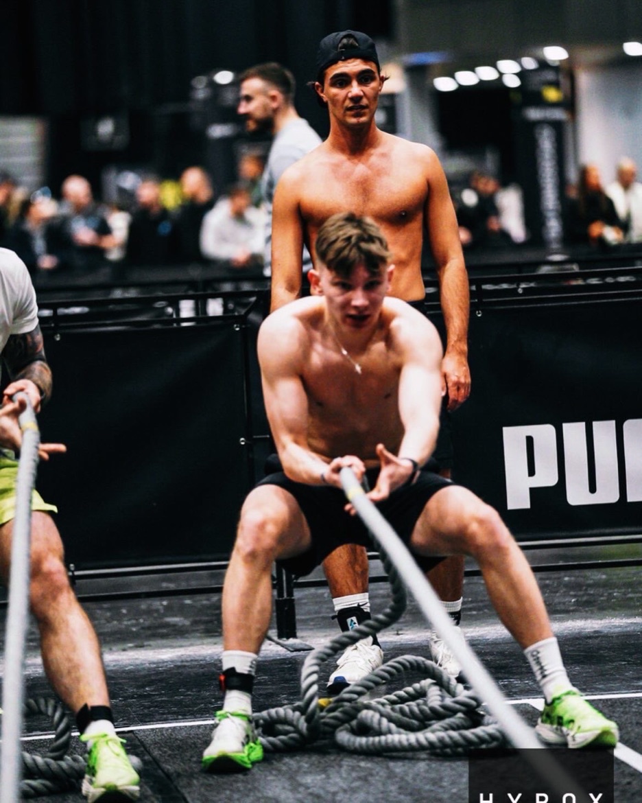 Arturs on the battle ropes at a HYROX event